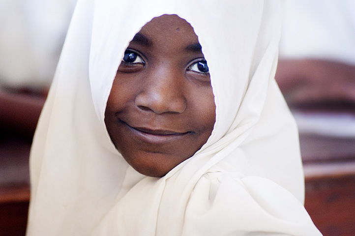 Photo of a teen girl in Tanzania, East Africa with headscarf looking at camera